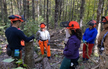 Group of people in safety gear in a wooded area.